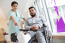 In the picture, there is a nurse helping a man in need.