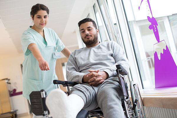 In the picture, there is a nurse helping a man in need.